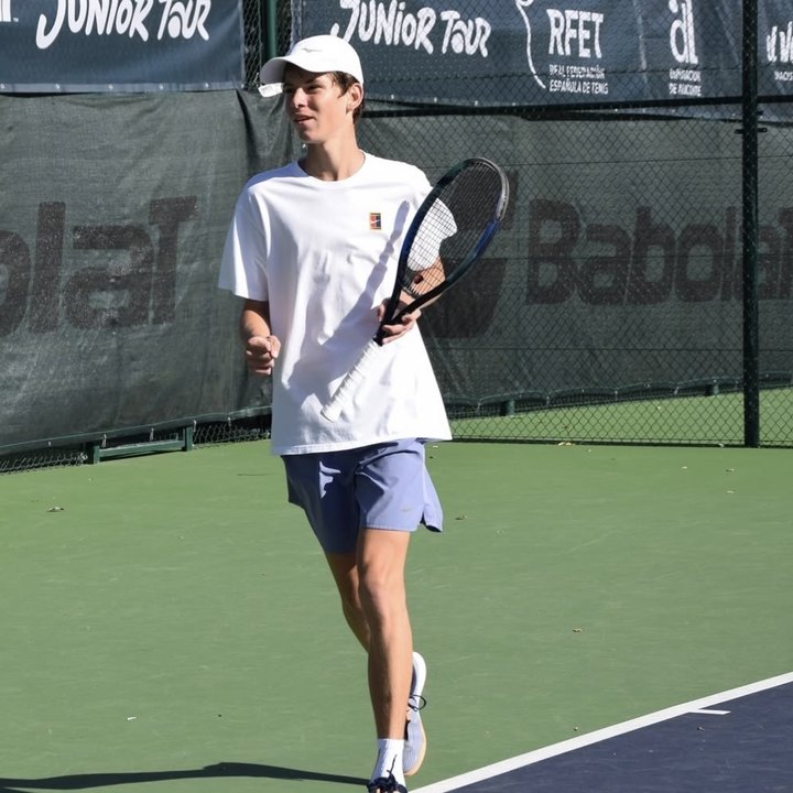 Georgiy G., aluno da IWS, em uma quadra de tênis em um torneio juvenil