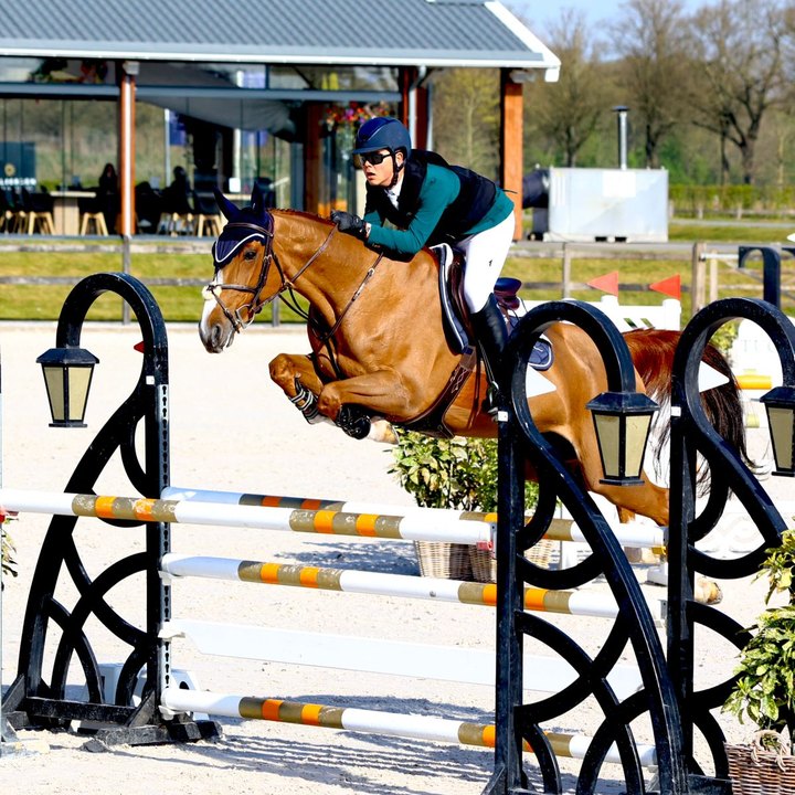 Peter G., aluno da IWS, saltando um obstáculo em uma pista de hipismo