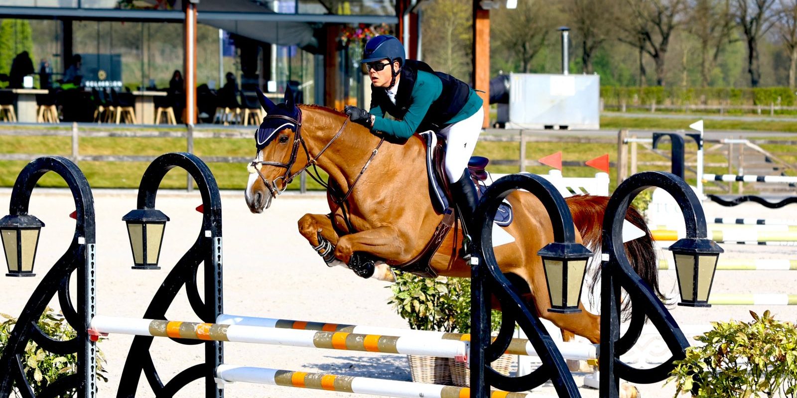 Peter G. and his horse clearing a fence in a competition arena