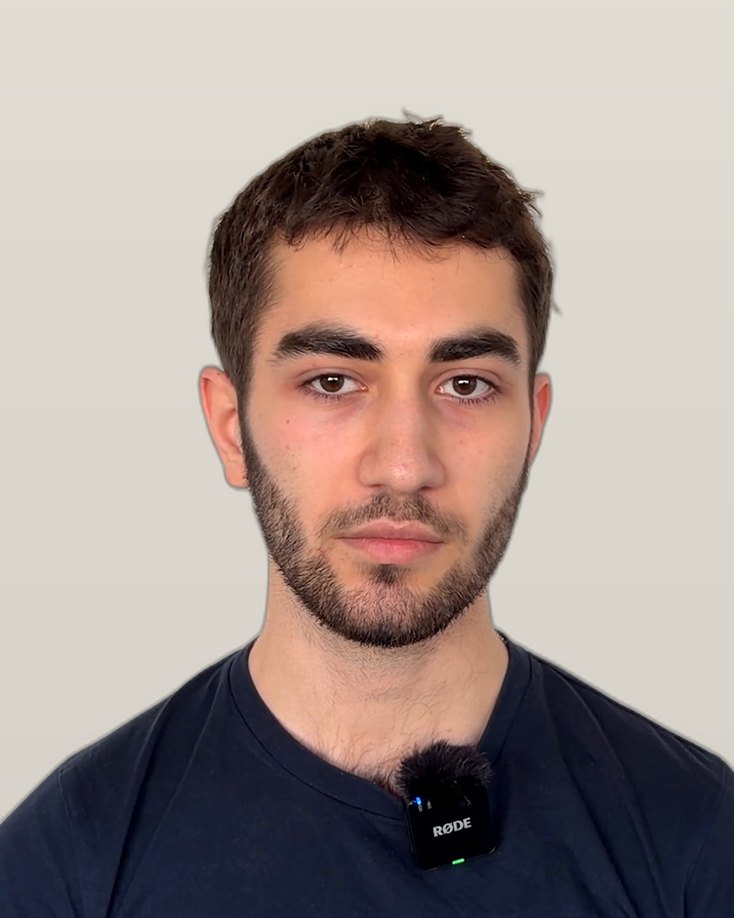 Emre K., an IWS alumnus with a short beard, in a dark T-shirt, looking at the camera