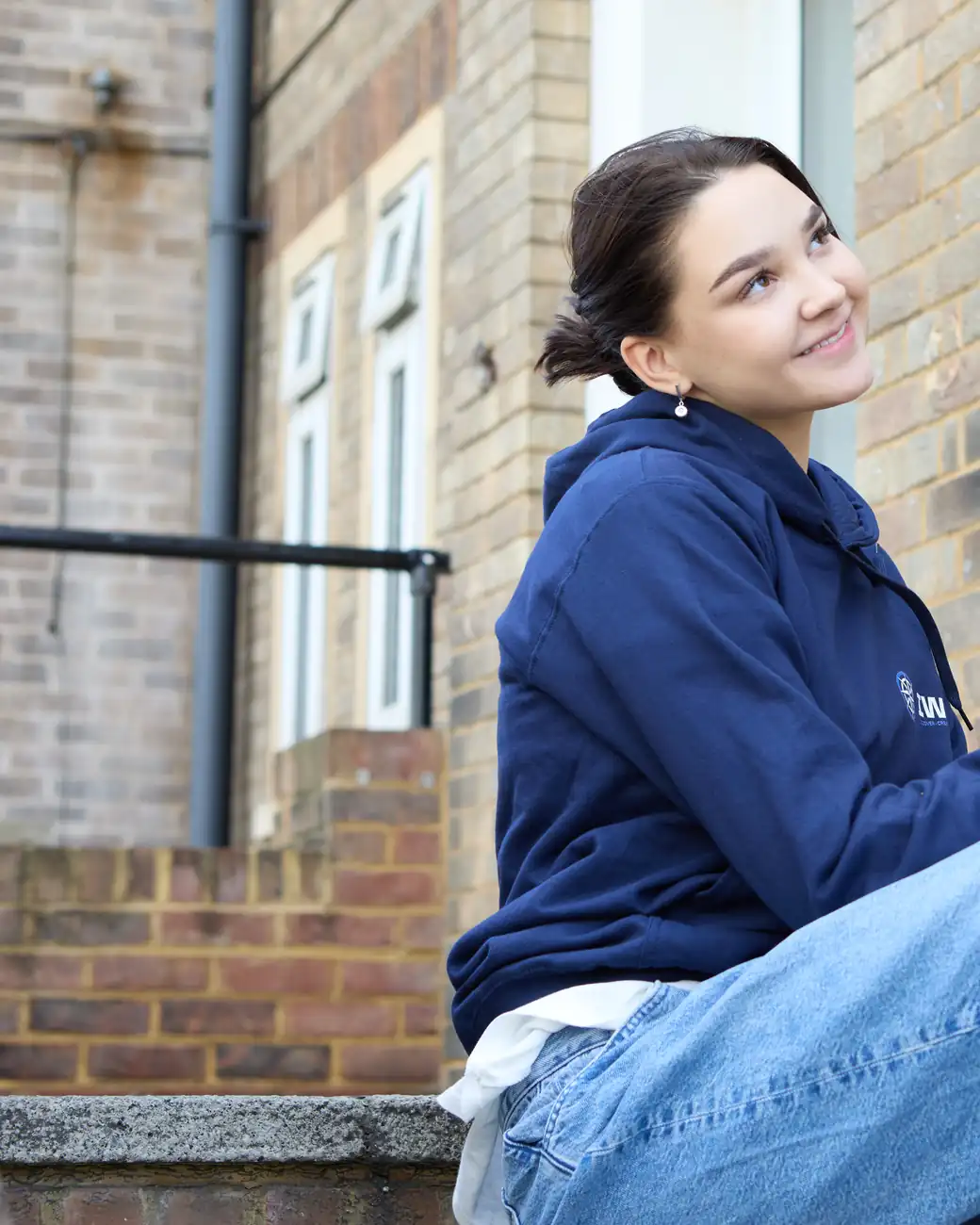 An IWS student smiling, tablet in hand