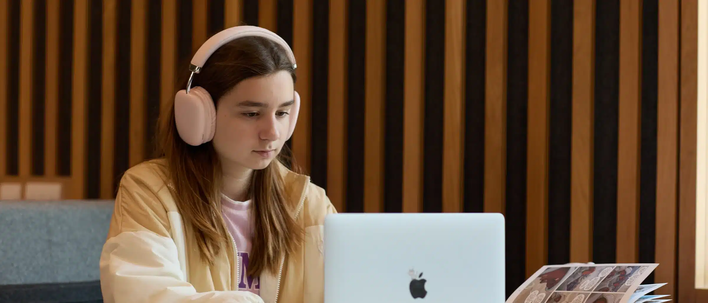 A student working through a lesson at home in headphones
